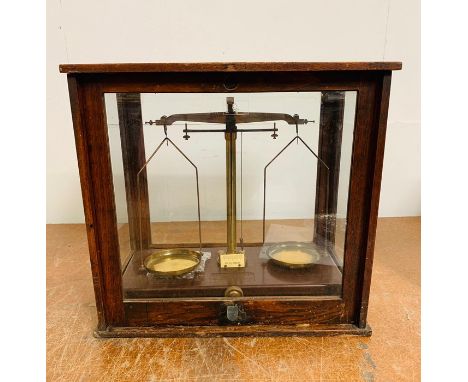 A set of scientific scales and weights in a separate box.
