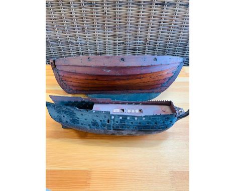 A Wooden hull of a boat and model kit hull of a ship