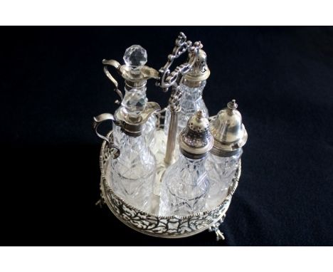 Victorian Cruet set Comprises a sterling silver stand and five condiment crystal bottles with silver neck and cut crystal sto
