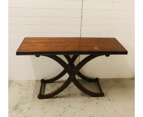 A large console table with a double curved cross base and stretchers 