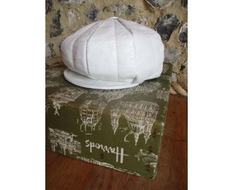 A 1960's cream leather ladies 'Mod' peak hat with button detail to the top centre together with a vintage green Harrods' hat 