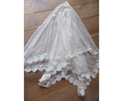 A 1930's cream 2 tier shoulder length wedding veil having a machine made button hole mesh background with an applique scallop