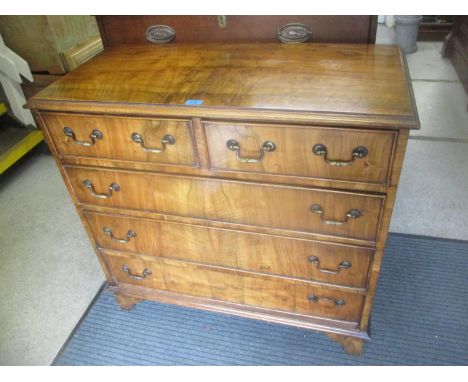 A 20th century walnut chest of two short and three long drawers on bracket feet 