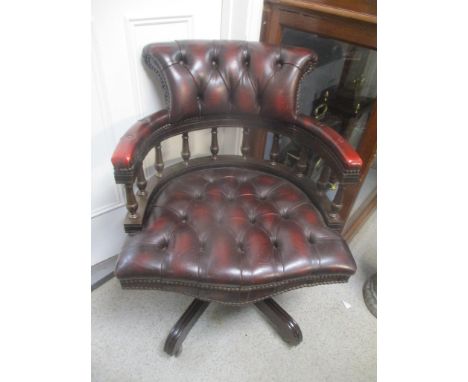 A reproduction leather button back captain's style swivel armchair 