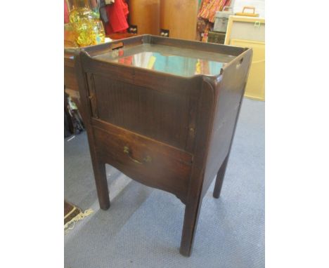 A Georgian mahogany commode having a tambour sliding door above pull out drawer below 