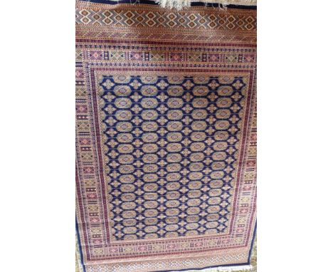 A Bokhara style carpet, having a blue field, 230 x 160cm