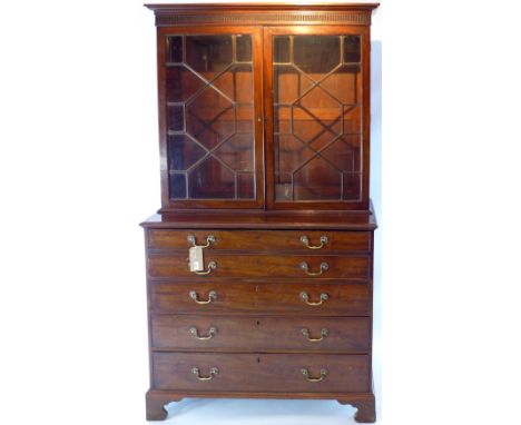 A Georgian bureau bookcase with astral glazed doors above secretaire and 3 graduating drawers below. raised on carved bracket