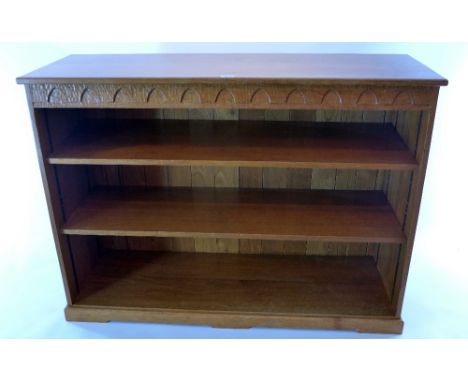 A light oak bookcase having carved frieze, H 92 x W 124 x D 42cm 