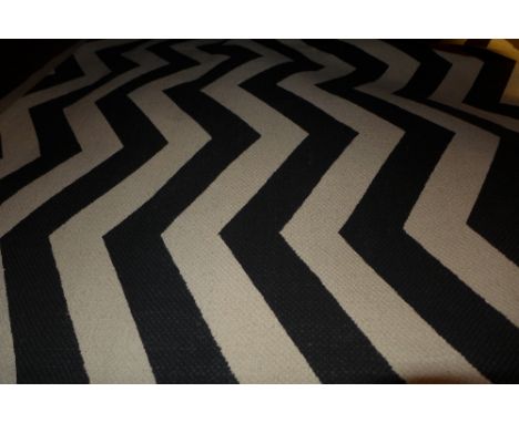 A contemporary carpet with a black and white chevron motif, 230 x 160cm