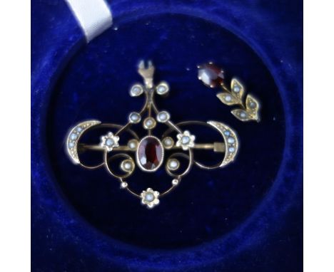 An early 20th century yellow metal, ruby and seed pearl set brooch, the floral finial broken (still present), W.3.7cm 