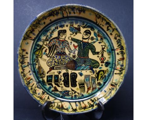 A Persian glazed ceramic bowl, decorated with two figures drinking to center, dated and marked to base, H.6cm Diameter 25cm 