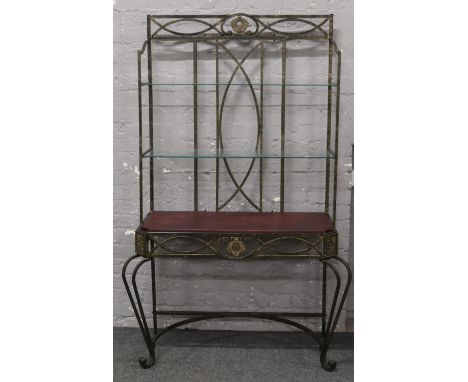 A metal console table with leather top, two glass shelves and raised on scrolling supports. 