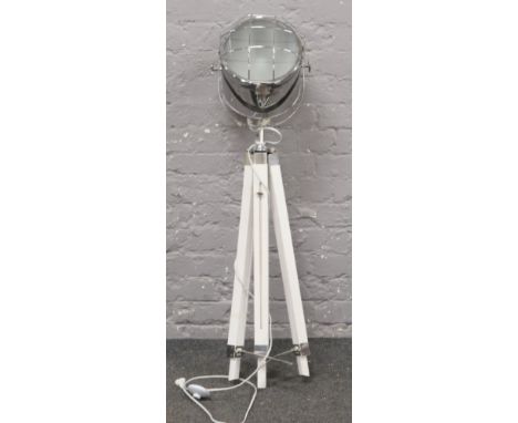 A chrome studio light on tripod stand. 