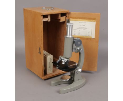 A cased Prinz students microscope with slides. 