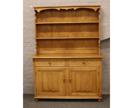 A carved and panelled light oak dresser, 137cm W x 180cm H x 48cm D. 