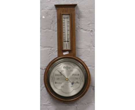 A carved oak banjo barometer by H. Pidduck &amp; Sons Ltd Hanley advertising. 