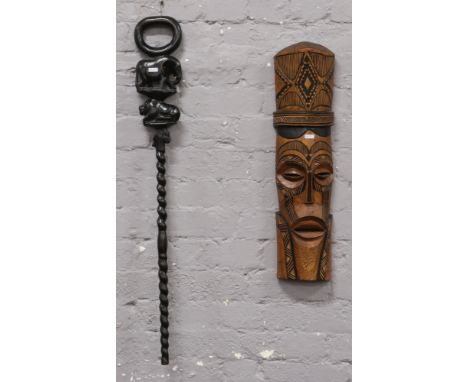 A carved African hardwood walking stick along with a tribal wall hanging. 