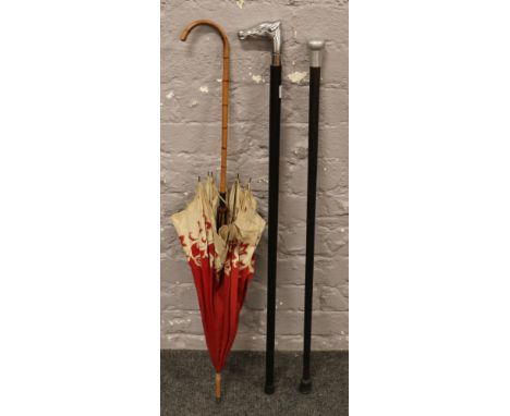 An Equestrian themed walking stick, a walking cane and a parasol. 