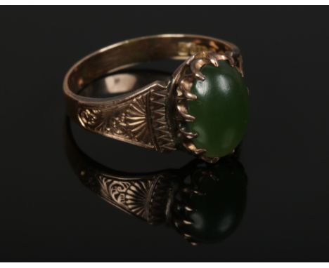 A 9ct gold ring set with a cabochon jade stone and with chased shoulders, size R1/2, assayed Chester 1916. 