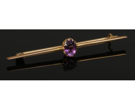A cased 9ct gold knife edge bar brooch set with an ovoid amethyst. 