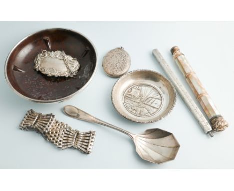 A collection of small silver items to include pin trays, locket, decanter label, spoon and mother of pearl checkerboard patte