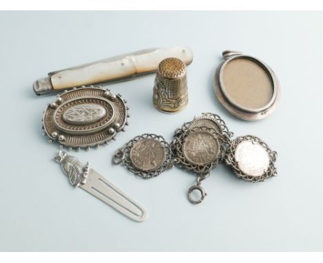A collection of small silver items to include mother of pearl handled fruit knife, brooches, bookmark etc