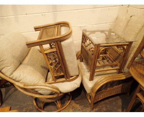 Two bamboo and conservatory chairs with upholstered cushions and similar stool and glass topped side table 