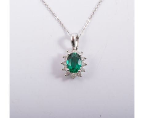 A diamond and green chrome diopside pendant and chain, an oval faceted green stone 6.5mm x 5mm surrounded by twelve brilliant