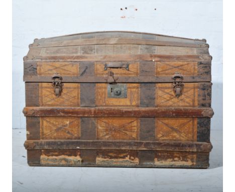 An early 20th century dome top and banded trunk, tooled leather panels, W83cm x D51cm x H58cm.