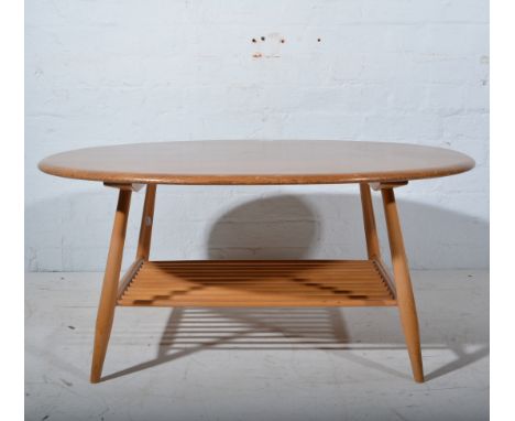 Ercol, a birch and elm coffee table, oval top with spindle magazine rack, width 100cm, depth 83cm, height 44cm.