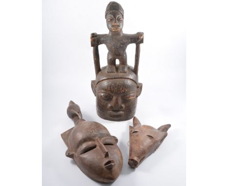 Four items of ethnographica, an indian male/female headrest 17cm high, a wooden mask with figure to top, 48cm, another mask w