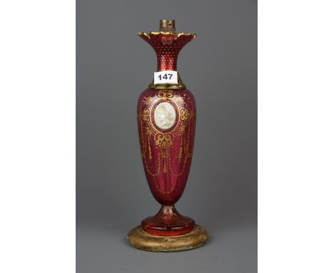 A Bohemian gilt cranberry glass lamp with an inset cameo, H. 35cm (needs rewiring).