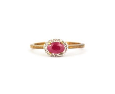 A 9ct yellow gold oval cut ruby and diamond set halo ring, (O).