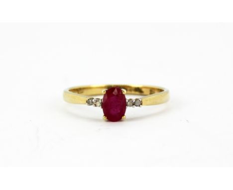 A 9ct yellow gold ring set with an oval cut ruby and brilliant cut diamond set shoulders, (N).