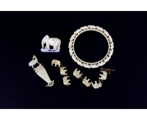 An early 20th Century carved ivory elephant bangle, internal Dia. 7.1cm, together with further similar period ivory items.