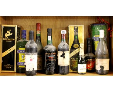 A group of mixed vintage bottles of alcohol.