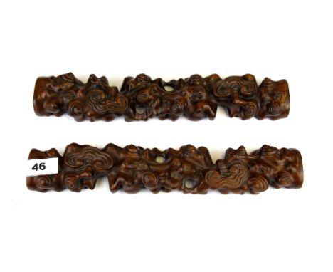 A pair of Chinese carved wooden scroll weights, L. 33cm.