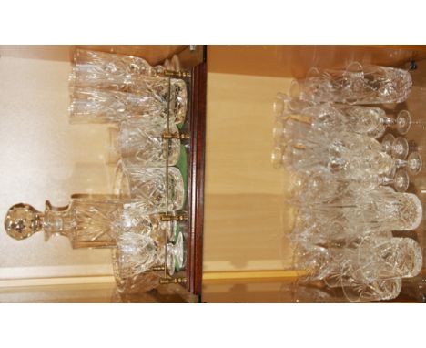 A cut crystal decanter with mahogany stand, cut crystal bowl and a quantity of cut crystal drinking glasses.