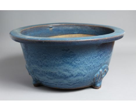 A LARGE CHINESE BLUE-GLAZED PLANTER, slightly raised on three moulded feet. 39.5cm diameter