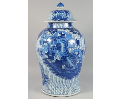 A VERY LARGE CHINESE BLUE AND WHITE PORCELAIN URN AND COVER painted with tigers against a fish scale background. 65cm high ov