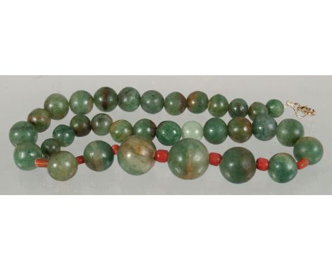 A SET OF GRADUATED JADE BEADS, the larger beads with small coral beads between.
