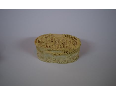 A 19th century carved ivory oval box and cover, probably Dieppe, carved in relief on all sides with figures in a continuous s