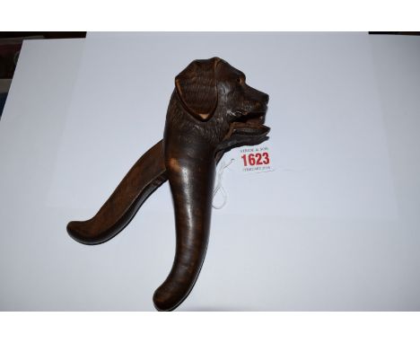 An early 20th century Black Forest carved wood novelty dog nutcracker, with glass inset eyes, 20cm long. 