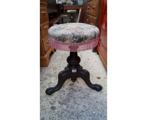 A Victorian carved rosewood and upholstered adjustable tripod piano stool.
