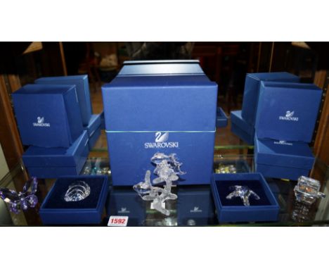 A Swarovski crystal clear glass figure group of four fish, 10cm high; together with four other Swarovski figures, all boxed. 