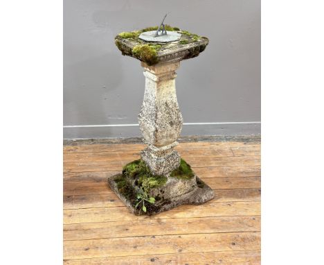A weathered composition stone sundial, of faceted columnar form on a square stepped base (loss to base). Height 86cm.