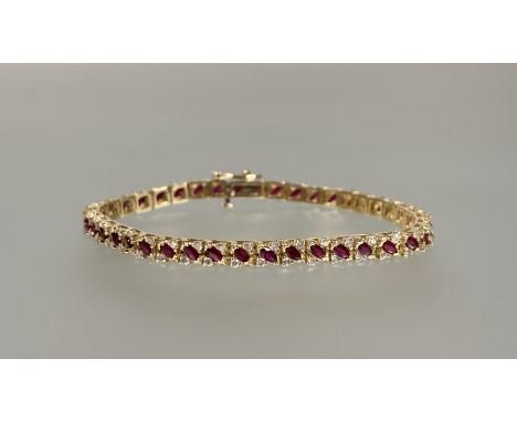 A ruby and diamond line bracelet, the articulated box links each set with an oval-cut ruby spaced by a pair of diamond points