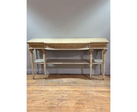 A painted and parcel-gilt breakfront side or serving table, in early 19th century style, the rectangular top with bowed centr