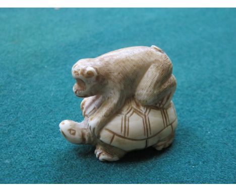 SMALL CARVED IVORY NETSUKE OF A TURTLE WITH MONKEY