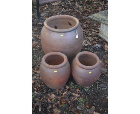 A LARGE GLAZED TERRACOTTA CYLINDRICAL PLANTER, rim diameter 42cm x height 60cm, together with two similar smaller planters (3